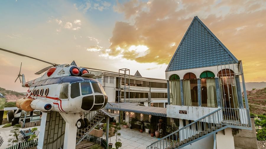 A view of a rooftop restaurant with a private helicopter, where people can sit and enjoy meals